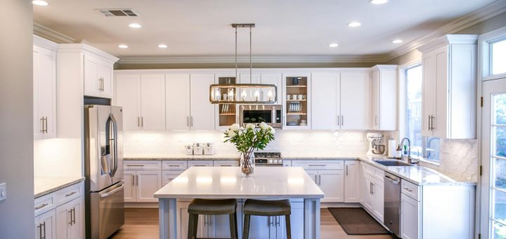 Spacious and elegant kitchen featuring white cabinetry, island, and stainless steel appliances.